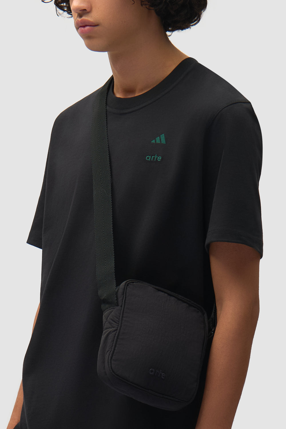 Sac Arte pour adidas noir/vert universitaire porté par un mannequin, vue de face en demi-corps