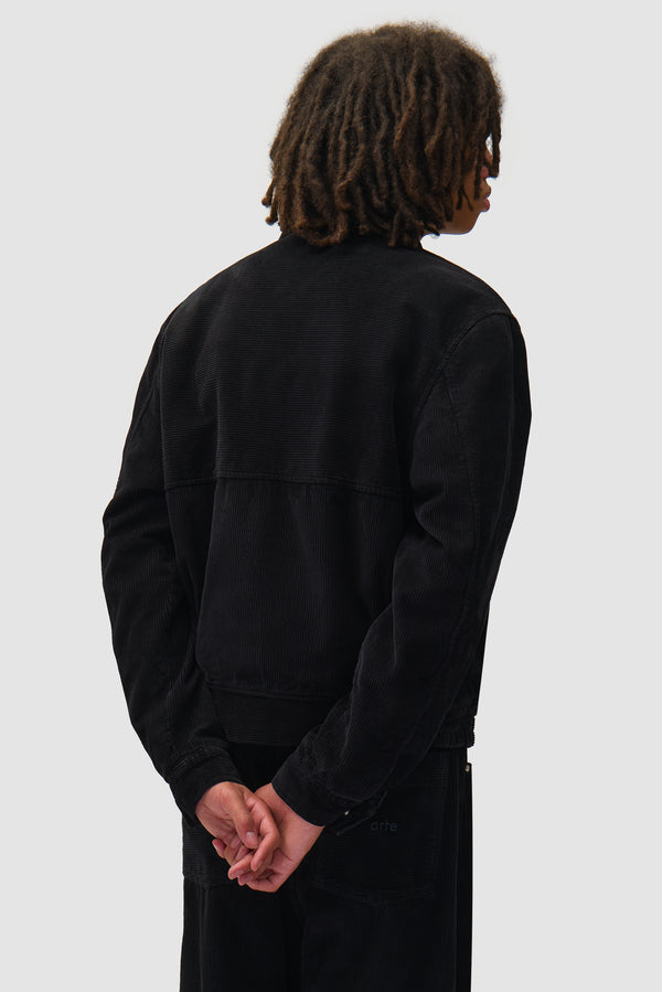 Corduroy Jacket in Black worn by a model, half-body back view