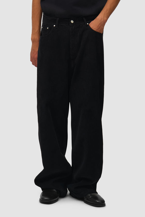 Corduroy Pants in Black worn by a model, half-body front view