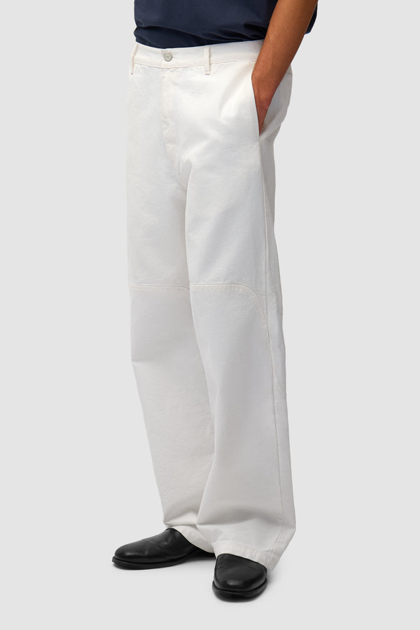 Round Knee Cut Pants in White worn by a model, half-body back view
