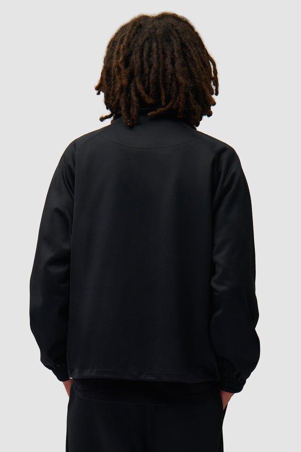 Carded Tracksuit Top in Black worn by a model, half-body back view