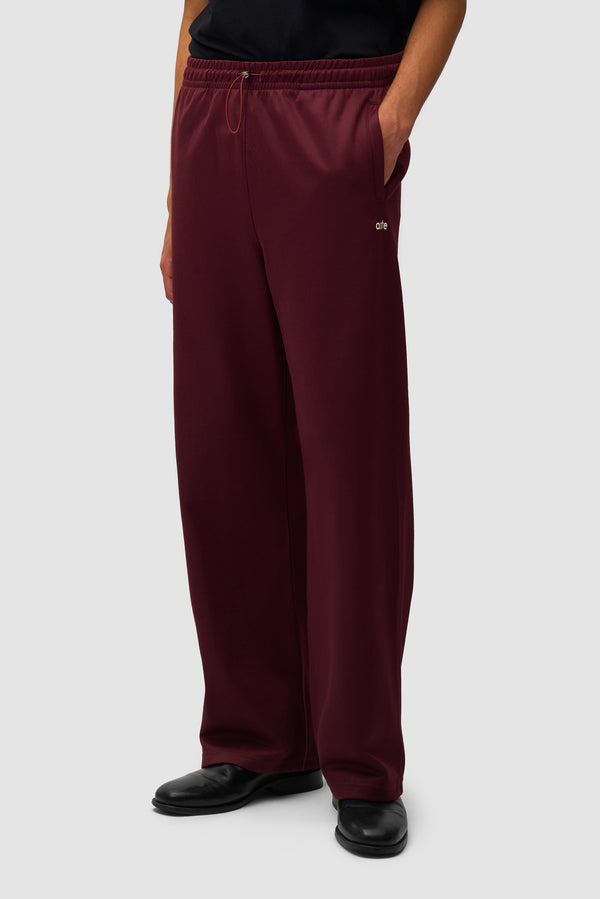 Carded Tracksuit Bottom in Bordeaux worn by a model, half-body front view