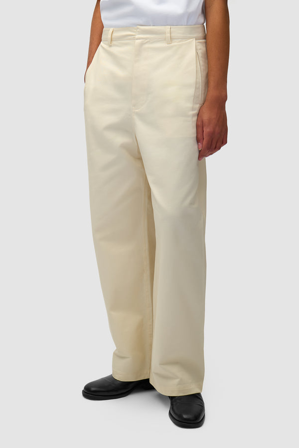 Dress Pants in Cream worn by a model, half-body side view