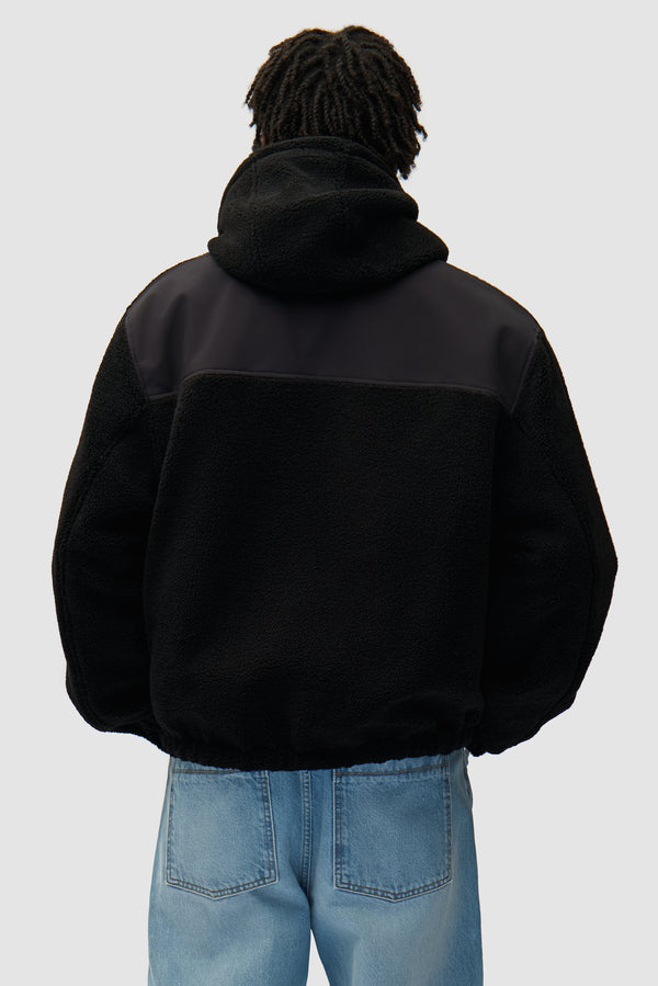 Nylon Technical Jacket in black worn by a model, half-body back view