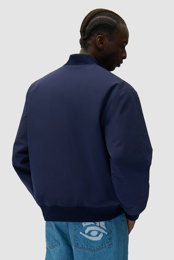 Eye Bomber Jacket in Navy worn by a model, half-body back view