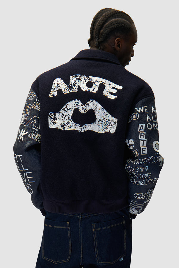 Graffiti Varsity Jacket in Navy worn by a model, half-body back view