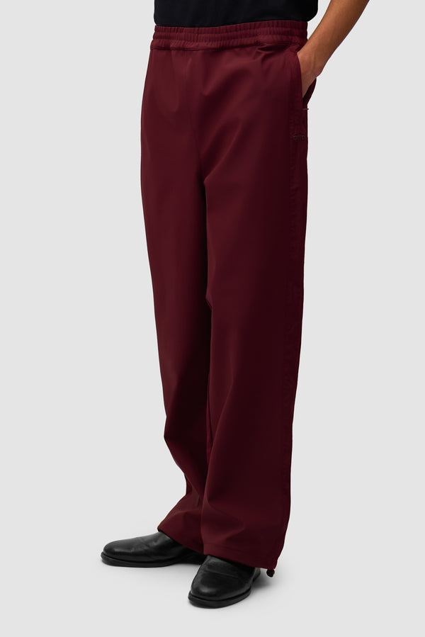 Nylon Track Pants in Bordeaux worn by a model, half-body front view