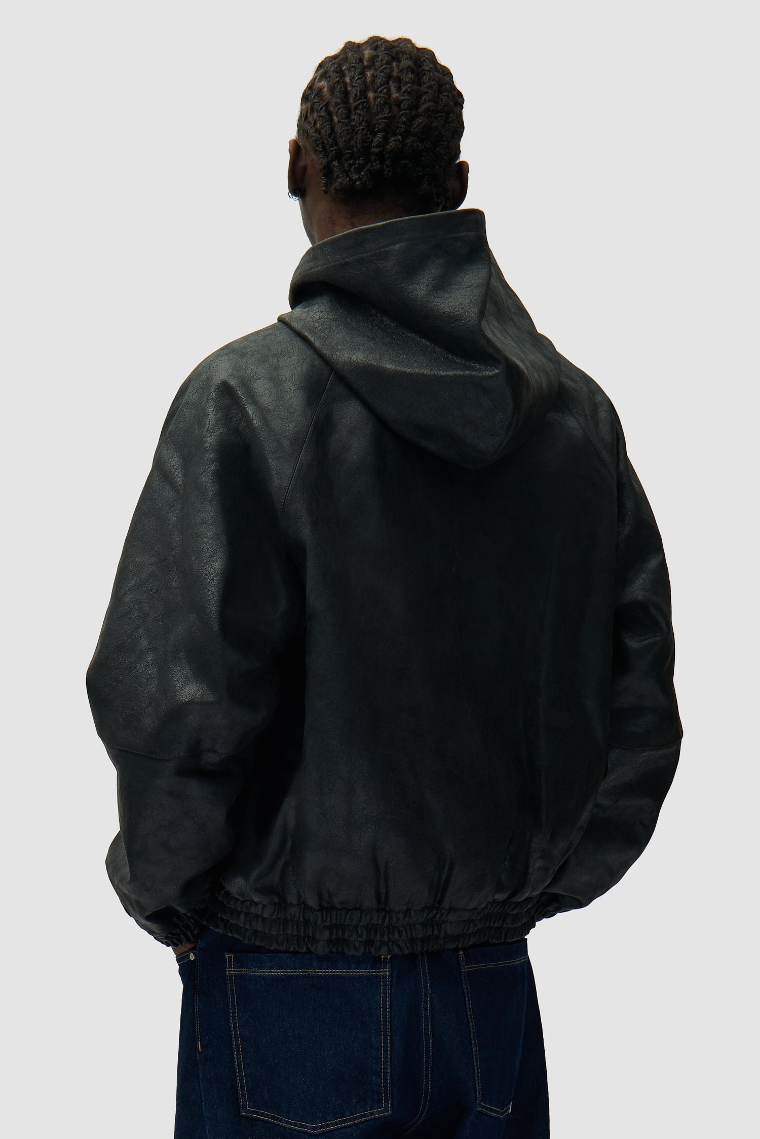 Veste en cuir craquelé noire portée par un mannequin, vue de dos à mi-corps