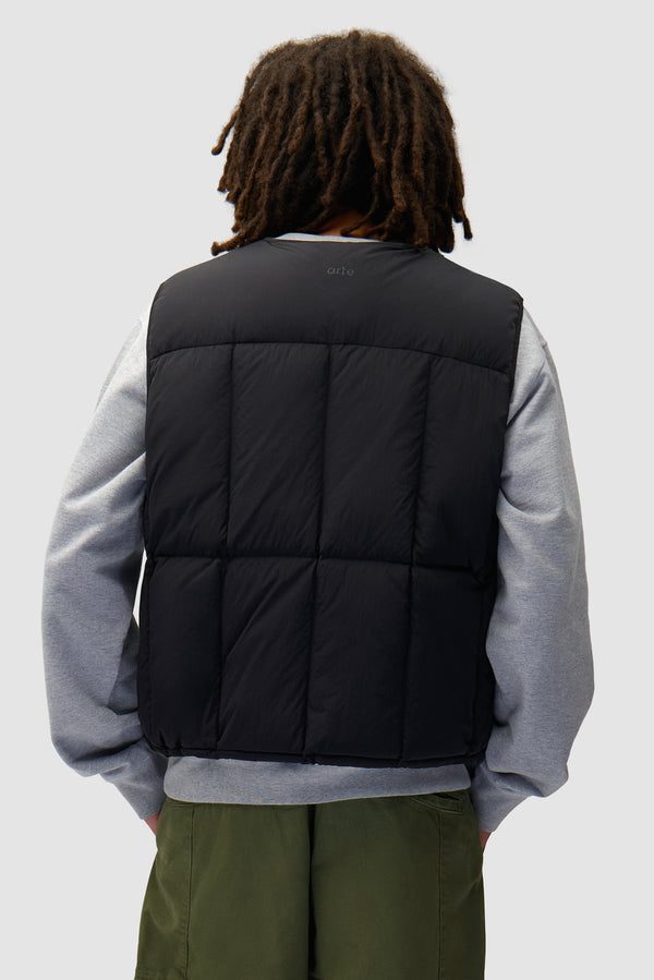 Puffer Vest in Black worn by a model, half-body back view