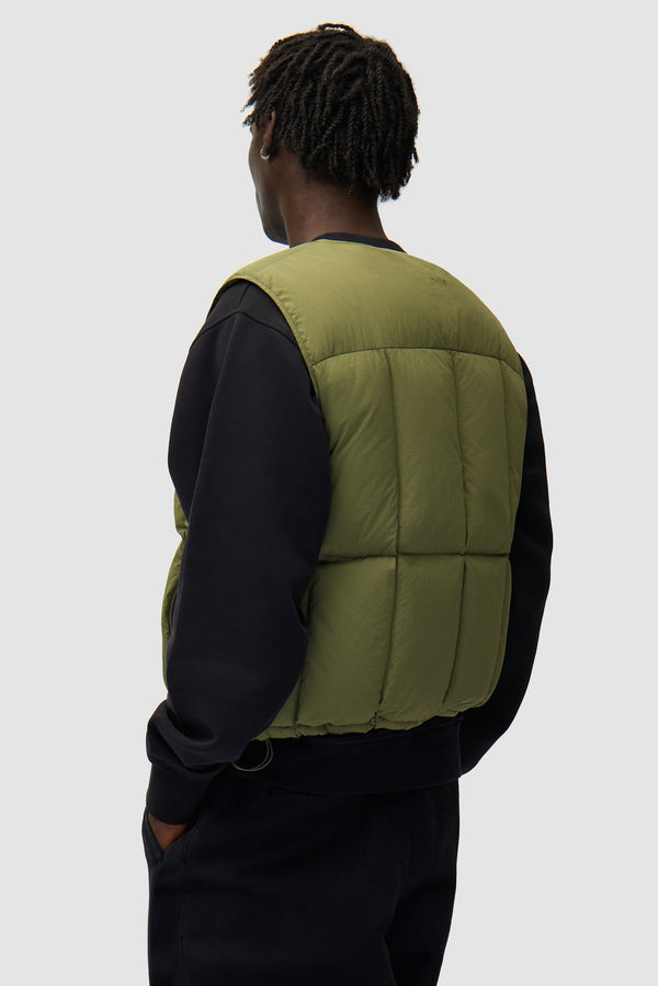 Puffer Vest in Green worn by a model, half-body back view