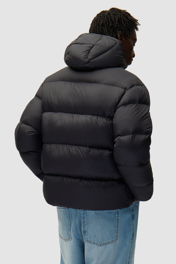 Arte Puffer Jacket in Black worn by a model, half-body back view