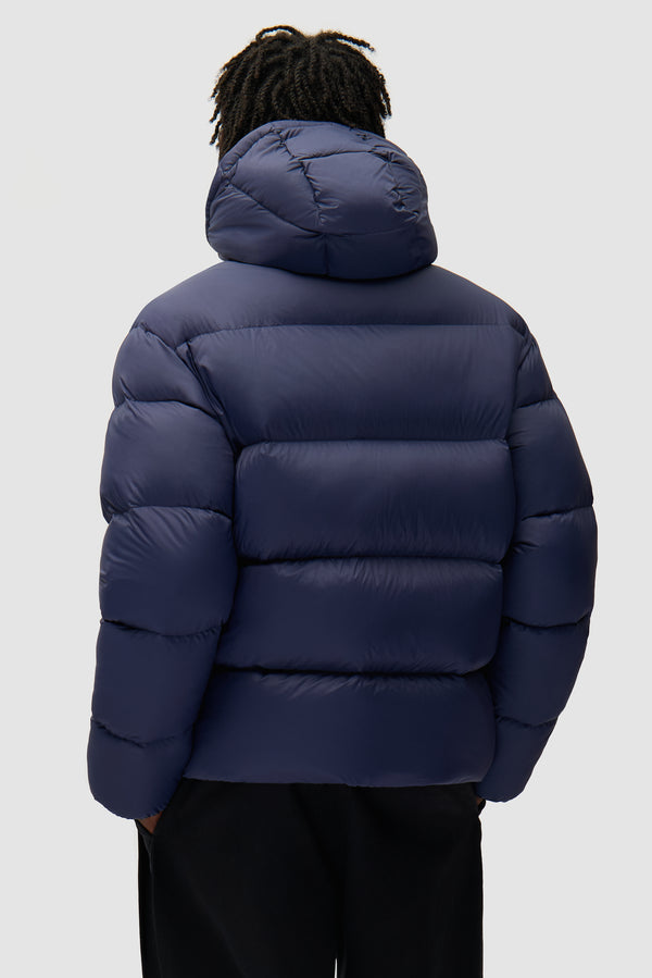 Arte Puffer Jacket in Navy worn by a model, half-body back view
