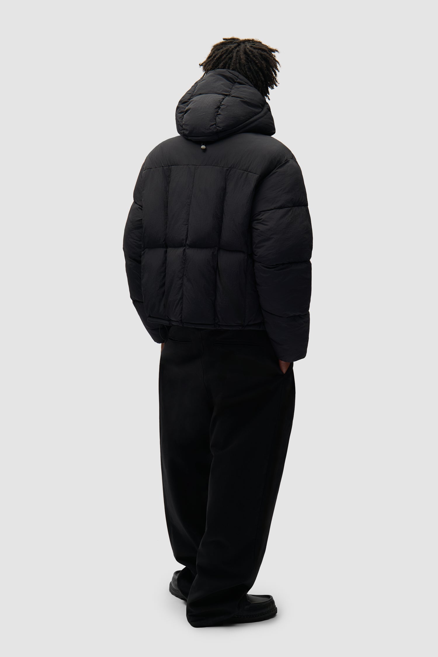 Special Cuts Puffer Jacket in Black worn by a model, full-body back