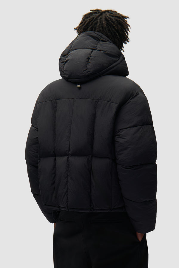 Special Cuts Puffer Jacket in Black worn by a model, half-body back view