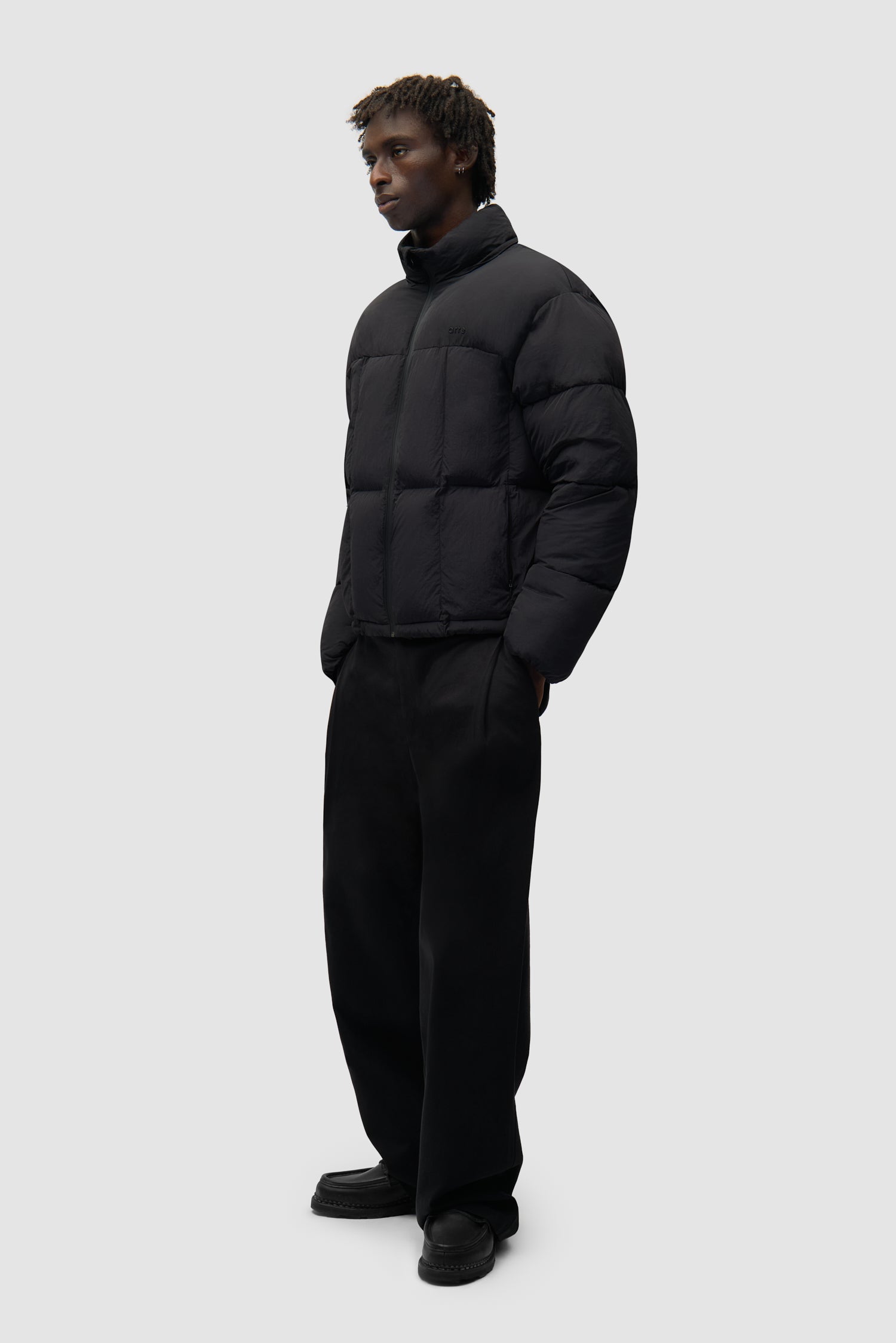 Special Cuts Puffer Jacket in Black worn by a model, full-body side