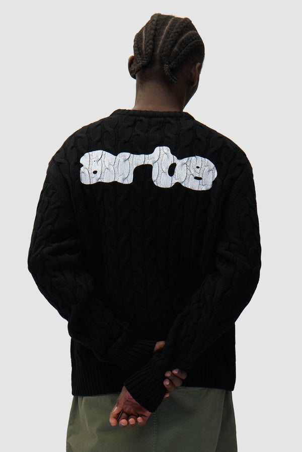 Arte Knit Sweater in Black worn by a model, half-body back view