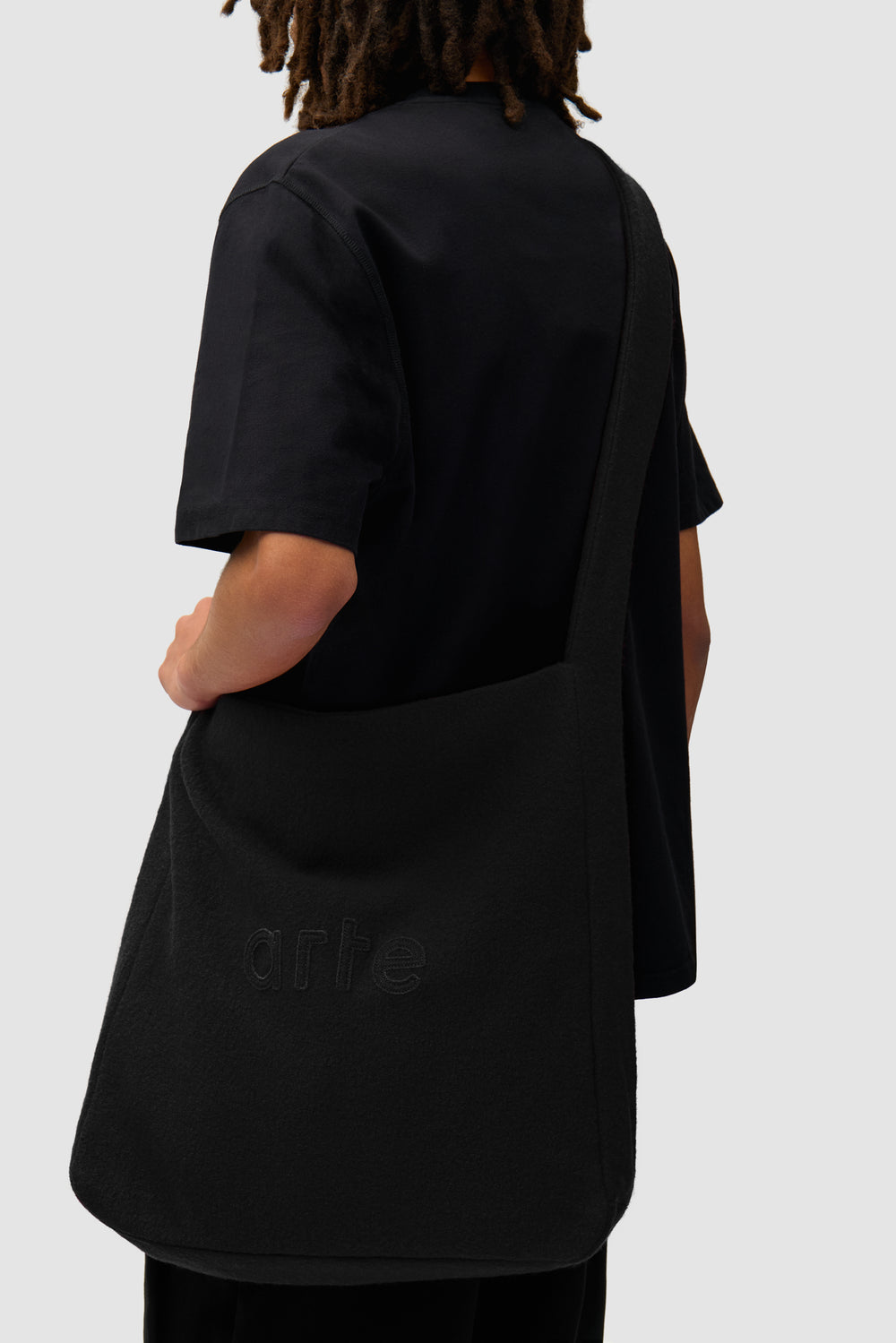 Boiled Wool Bag in Black worn by a model, half-body view