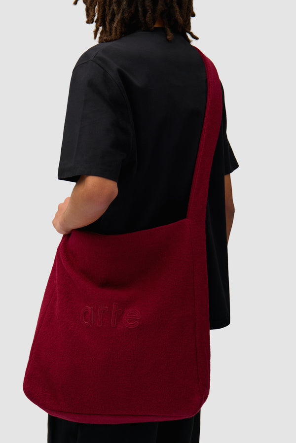 Boiled Wool Bag in Bordeaux worn by a model, half-body view