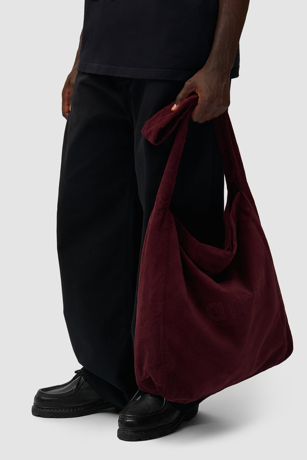 Corduroy Body Bag in Bordeaux worn by a model, half-body view