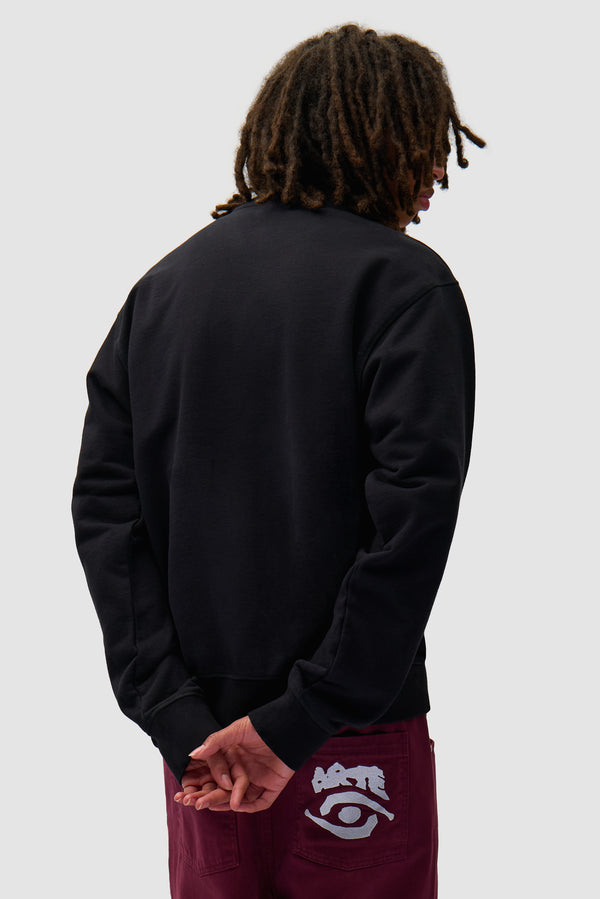 Eye Front Crewneck in Black worn by a model, half-body back view