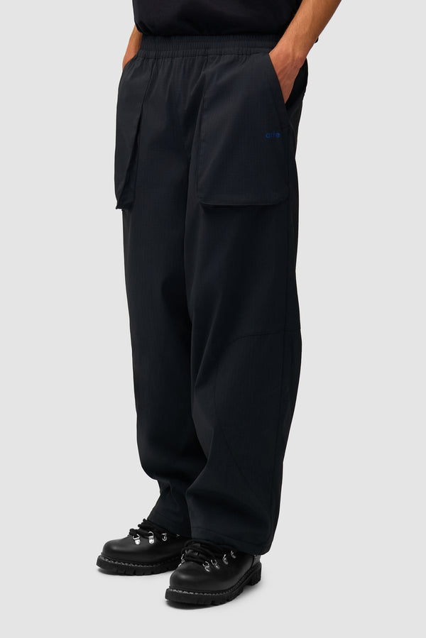 Technical Polar Pants in Black worn by a model, half-body side view