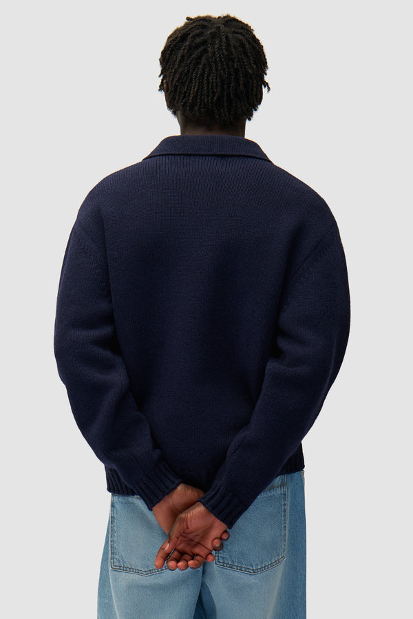 Polo in Navy worn by a model, half-body back view