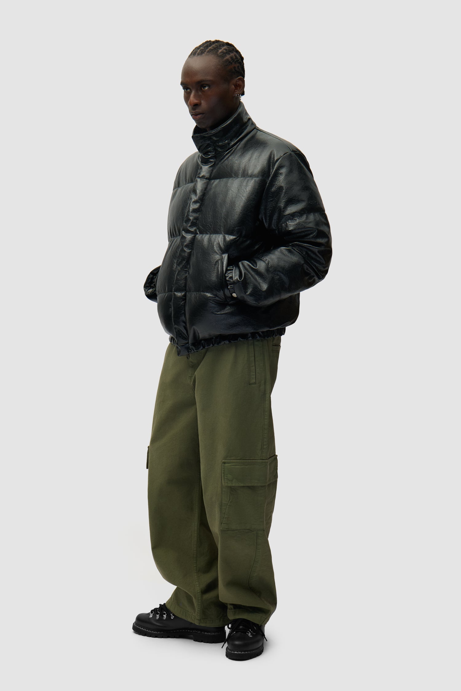 Doudoune à col montant noire portée par un mannequin, vue de profil en pied