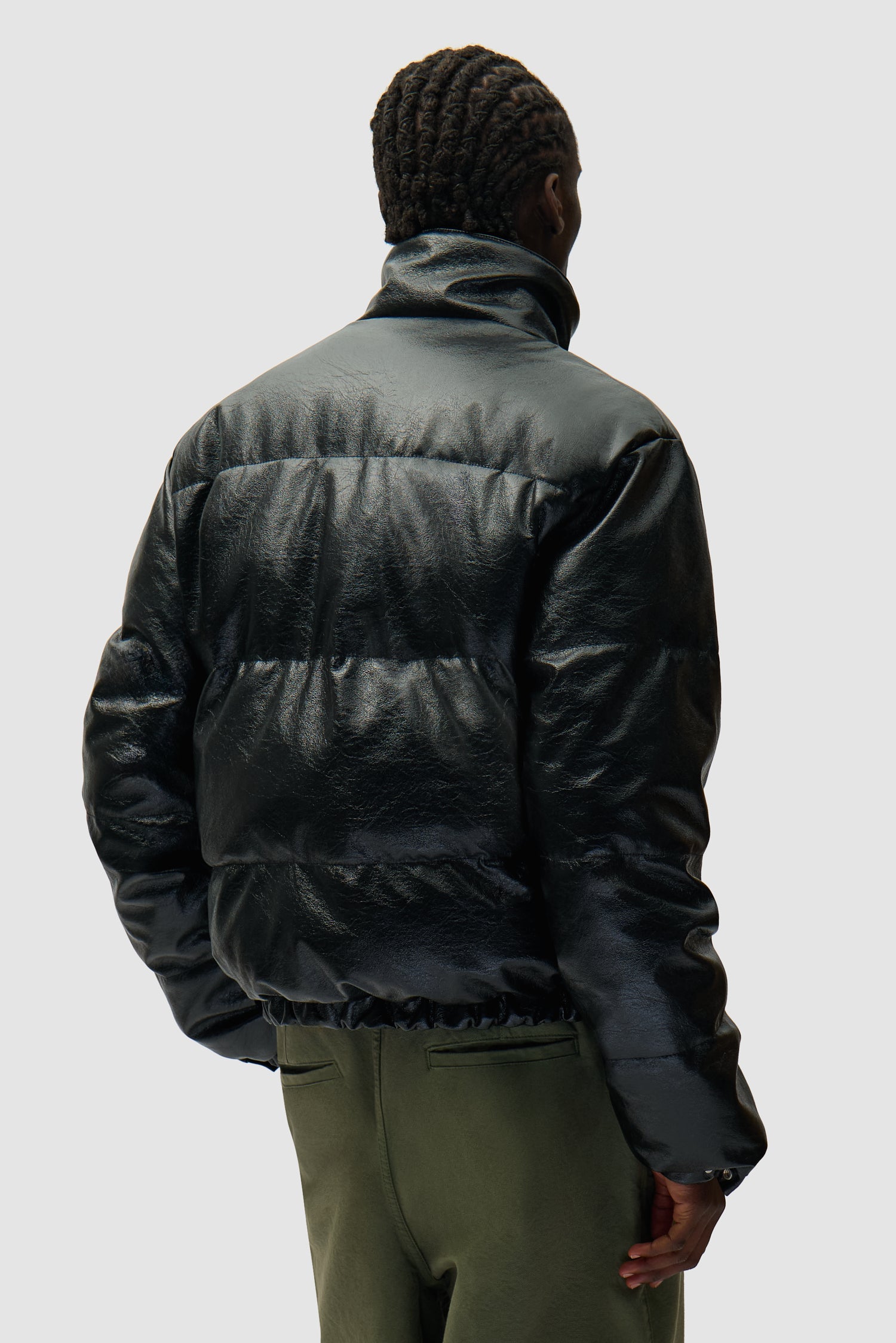 Doudoune à col montant noire portée par un mannequin, vue de dos en demi-corps