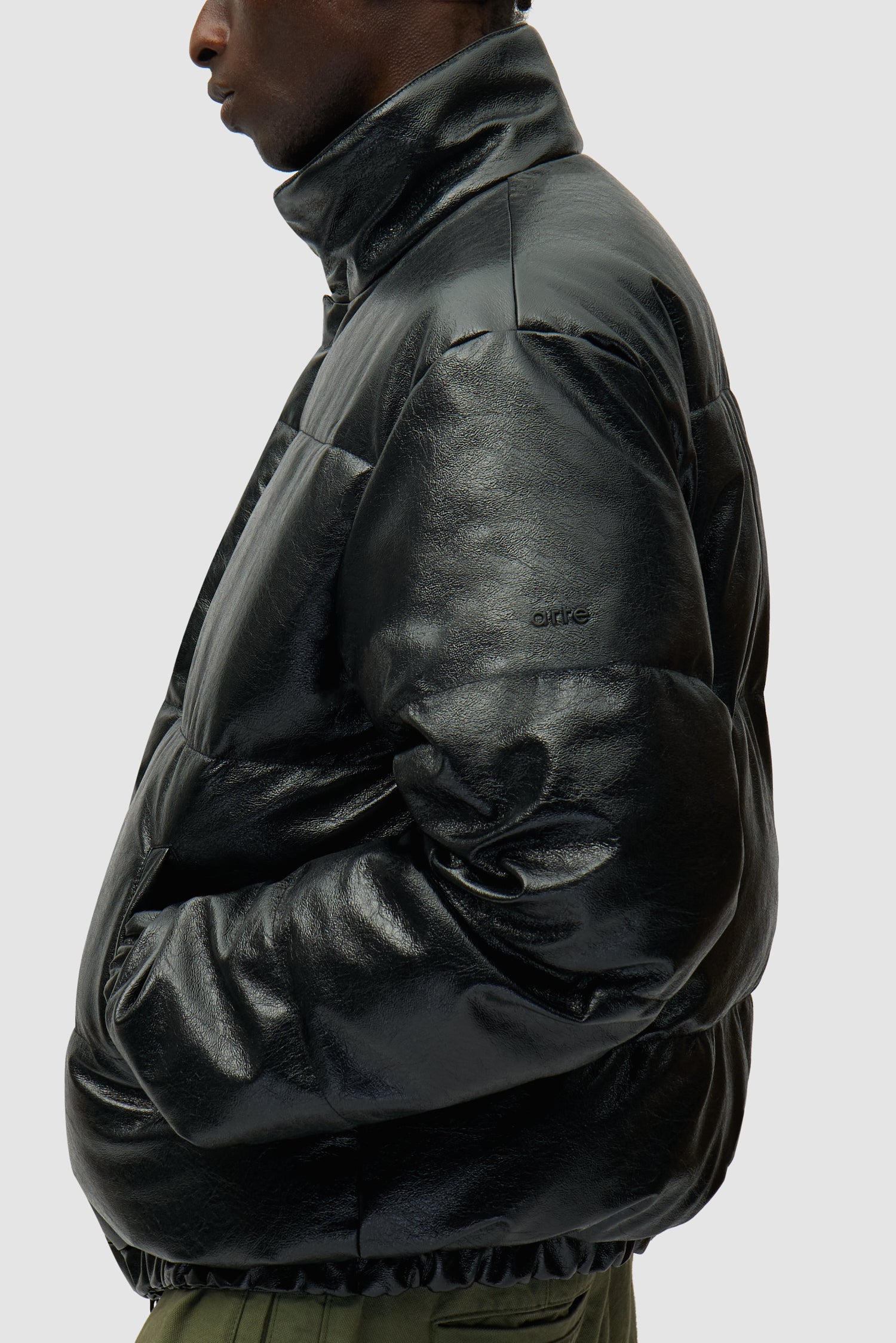 Doudoune à col montant noire portée par un mannequin, vue de profil à mi-corps