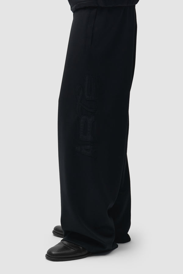 Polyform Nylon Track Pants in Black worn by a model, half-body front view