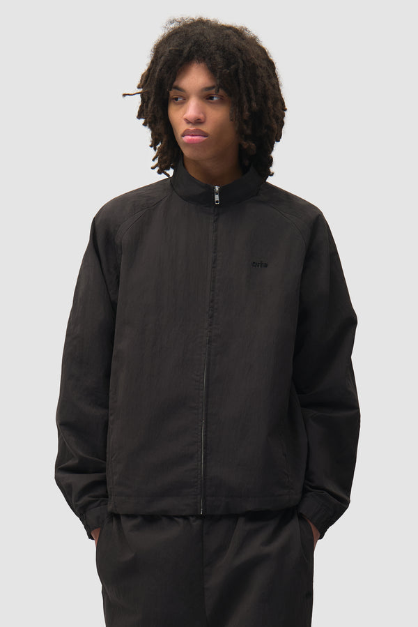 Uniform Track Jacket in Black worn by a model, half-body front view