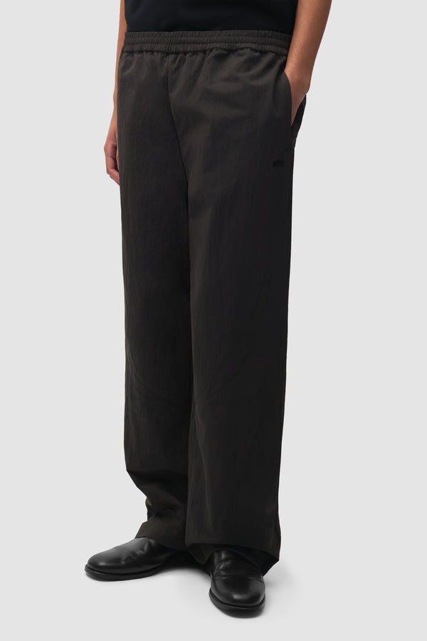 Uniform Track Pants in Black worn by a model, half-body front view