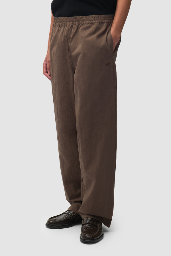 Uniform Track Pants in Brown worn by a model, half-body front view