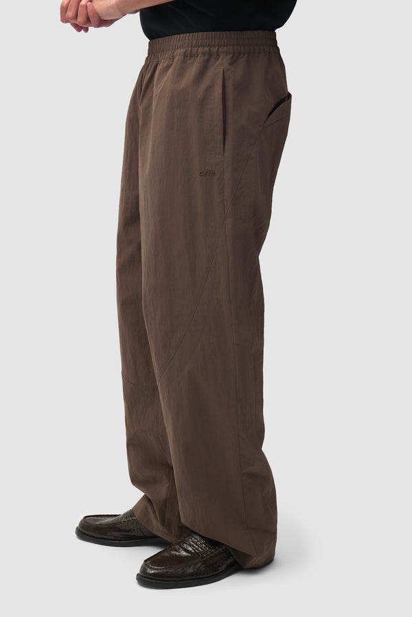 Uniform Track Pants in Brown worn by a model, half-body back view