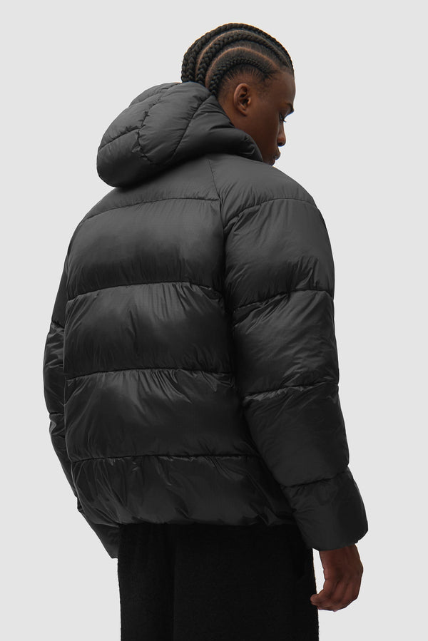Ripstop Hooded Puffer in Black worn by a model, half-body side view