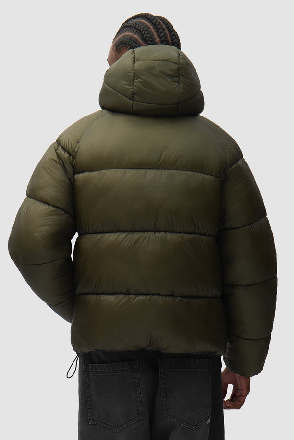 Ripstop Hooded Puffer in Green worn by a model, half-body back view