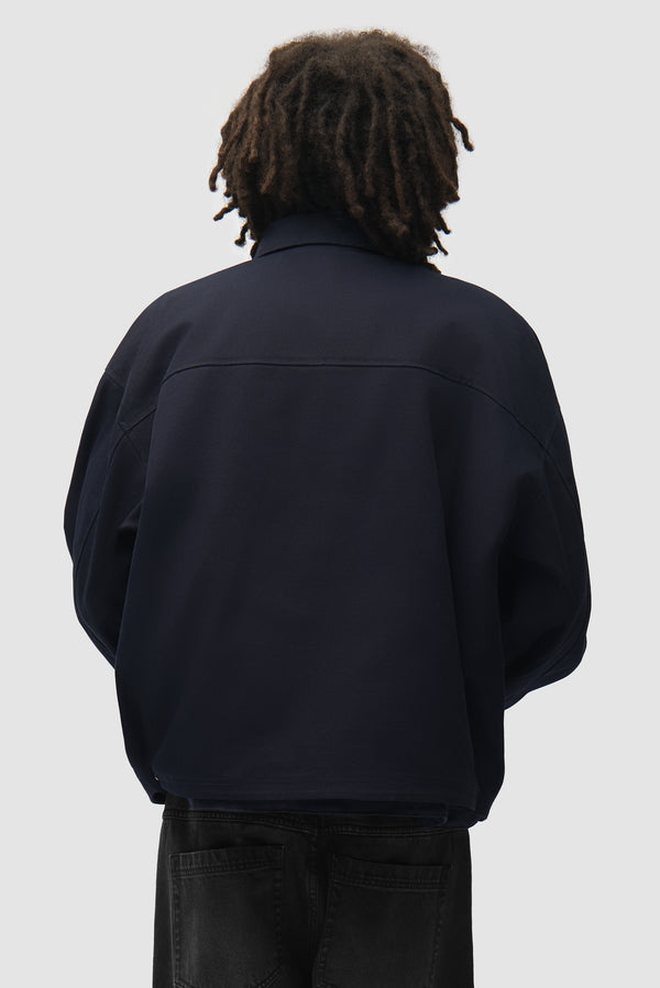 Canvas Atelier Jacket in Navy worn by a model, half-body back view
