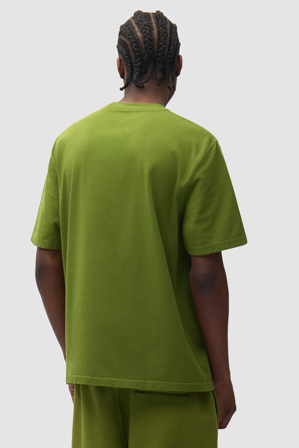 Cor T-shirt in Green worn by a model, half-body back view