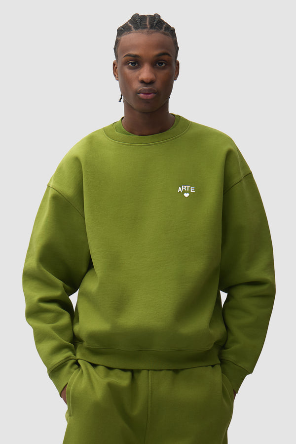 Cor Crewneck in Green worn by a model, half-body front view