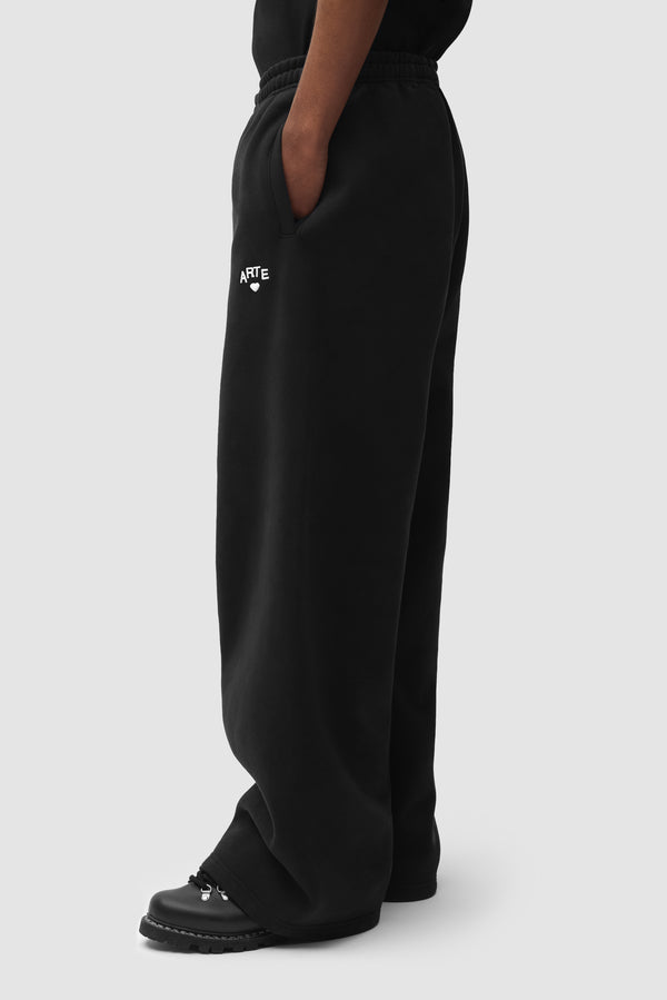 Cor Sweatpants in Black worn by a model, half-body back view