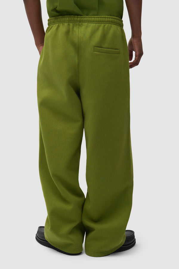 Cor Sweatpants in Green worn by a model, half-body back view
