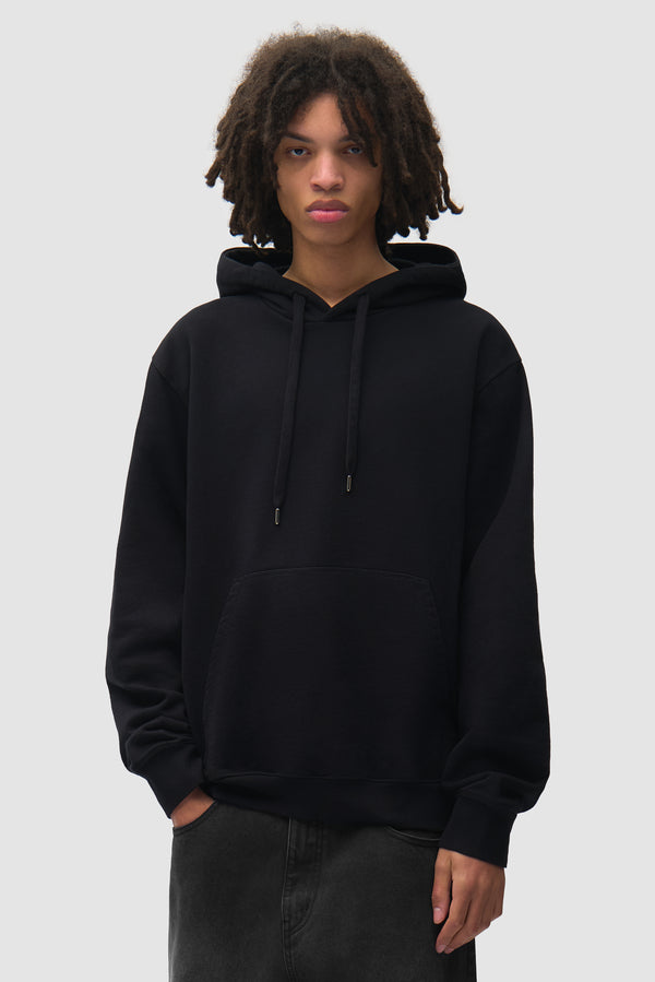 Disposable Hoodie in Black worn by a model, half-body front view