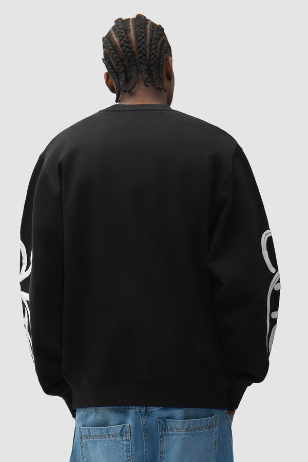 Swirl Crewneck in Black worn by a model, half-body back view