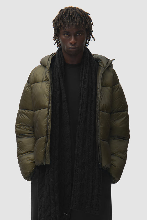 Wool Cable Knit Scarf in Black worn by a model, half-body front view