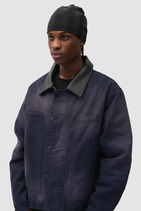 Structure Rib Beanie in Black worn by a model, half-body front view
