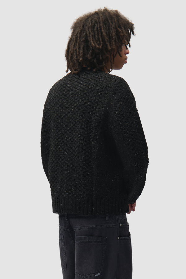 Speckle Cable Knit Cardigan in Black worn by a model, half-body back view
