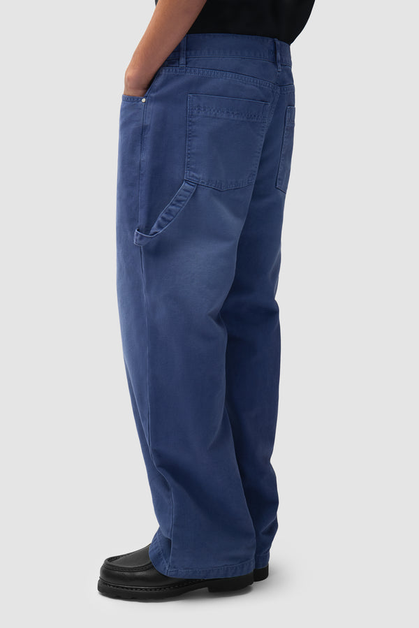 Atelier Uniform Denim Pants in Navy worn by a model, half-body side view
