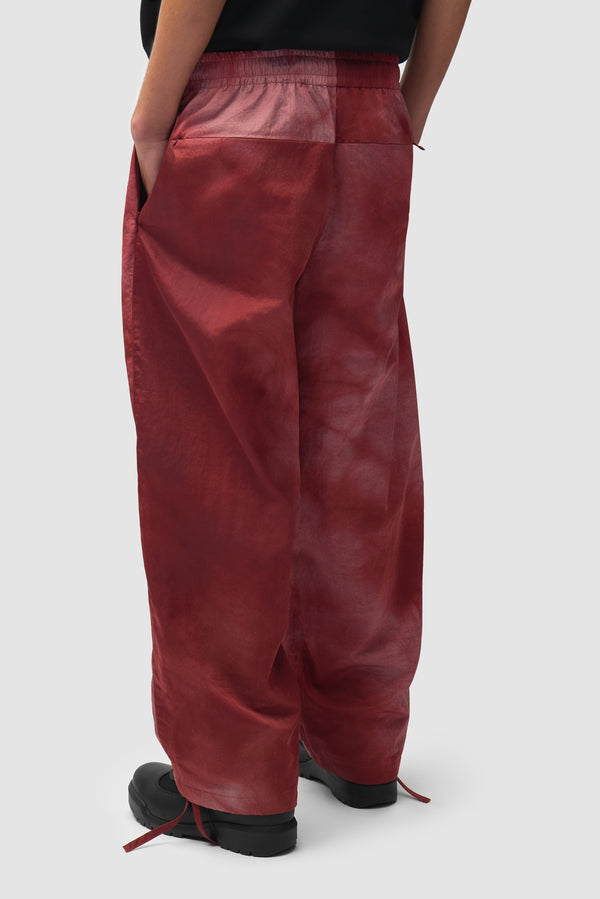Sunfade Aero Track Pants in Bordeaux worn by a model, half-body side view