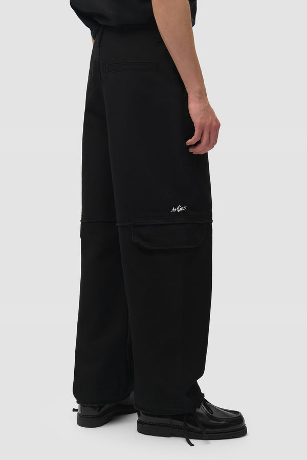 Deconstructed Cargo Pants in Black worn by a model, half-body back view