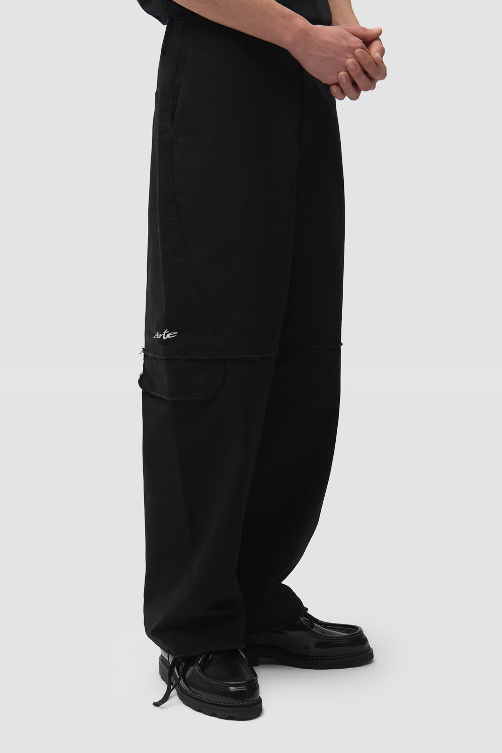 Deconstructed Cargo Pants in Black worn by a model, half-body side view